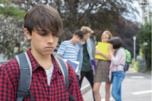 unhappy boy being gossiped about by school friends-img-blog