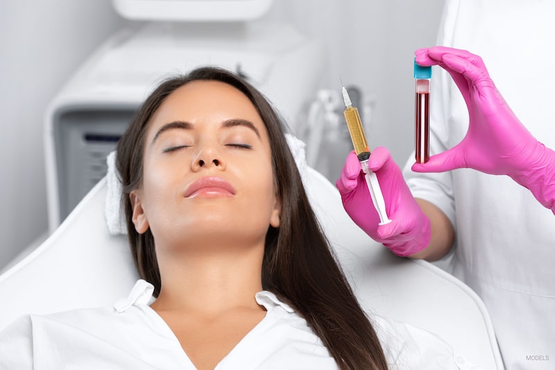 Beautiful woman lying back while a cosmetic surgeon prepares a PRP injection